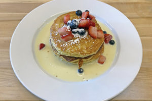 Sweet, fluffy Tres Leches pancakes are listed under desserts on the Con Huevos menu.
