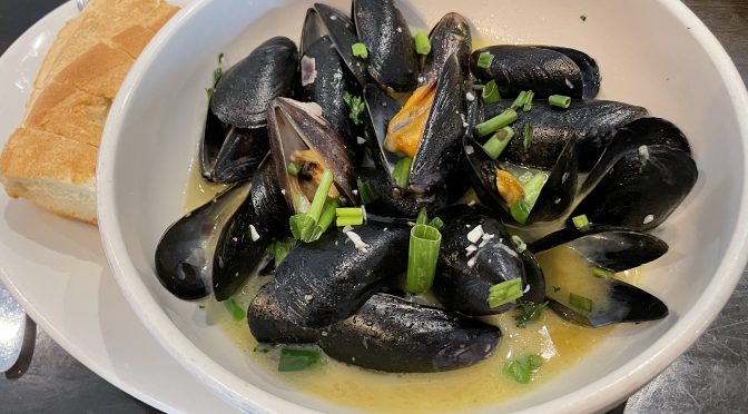 A large bowl of 16 mussels meunière comes swimming in a herbal, buttery traditional French white-wine sauce, with Italian-style bread to mop it up.
