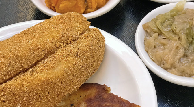 Fried catfish with sides of sweet potatoes, greens and cabbage at Irma Dee’s.