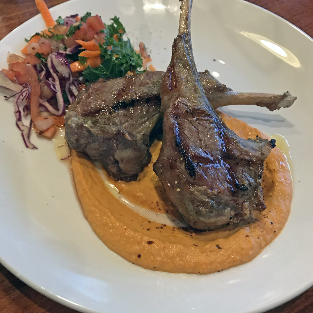 Mojito’s chuleta de cordero, grilled lamb chops with piquillo hummus.
