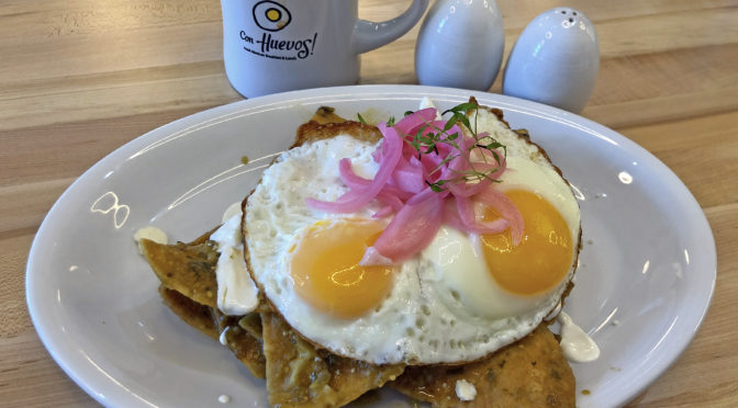 Chilaquiles topped with two eggs sunny-side-up at Con Huevos.