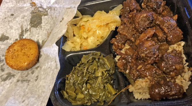 Oxtail dinner at Roof Top Grill, with Jamaican cabbage, collards, and a corn muffin.