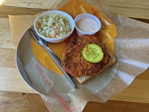 Golden-brown vegan “chickin” tenders get the full, fiery Nashville hot chicken treatment at Joella’s. 