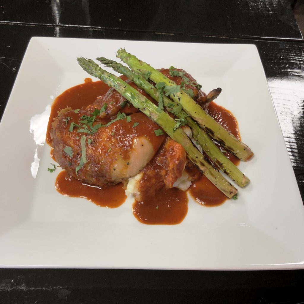 Chilakiles’ pollo rostisado, roast chicken blanketed in gently spicy red-chile sauce.