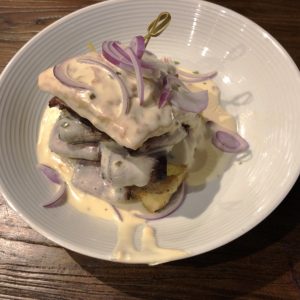 Down One Bourbon Bar’s massive smothered brisket biscuit makes a meal in itself.