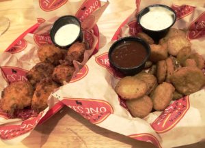 Crunchy fried appetizers at Joe’s Older Than Dirt: Cheese fritters (left) and Joe’s fried pickles.