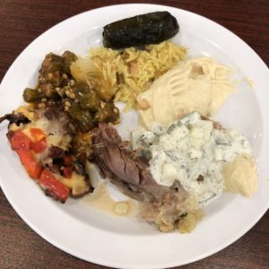 Pulled chunks of Al Hamra’s whole roast lamb are surrounded by a stuffed grape leaf, okra, rice, hummus, yogurt-cucumber mix, and tomatoes, eggplant and lamb.