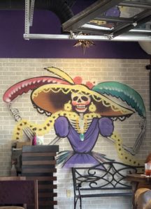 La Catrina, an iconic figure of the Day of the Dead, is prominently featured in murals at the restaurant that bears her name.
