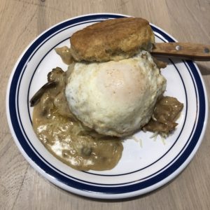 Biscuit Belly’s Edgy Veggie stacks an egg, cheese, and fried green tomato on an oversize biscuit bathed in thick mushroom gravy.