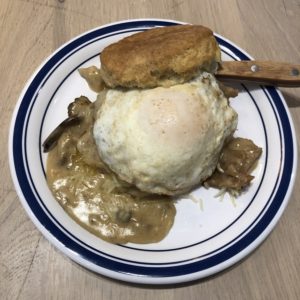 Biscuit Belly’s Edgy Veggie stacks an egg, cheese, and fried green tomato on an oversize biscuit bathed in thick mushroom gravy.