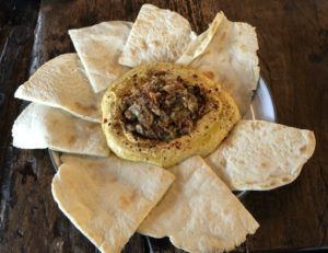 Butchertown Grocery Bakery's creamy, light carrot hummus is topped with spicy giardiniera and served with flaky, light piadina flatbread triangles.