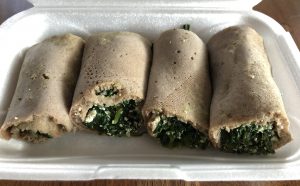 The kosta wrap appetizer at Queen of Sheba fills rolls of injera with sauteed fresh spinach, onions, garlic, and house-made aybe (house-made cottage cheese).