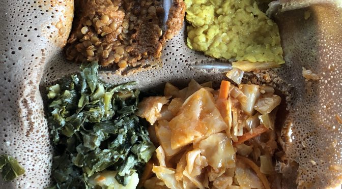The veggie combination at Queen of Sheba tops injera with two colors of lentil misir wot, atakilt and gomen wot.