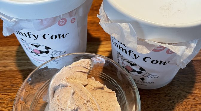 Pints of Comfy Cow peppermint stick and cinnamon mon ice cream flank a scoop of cinnamon mon.