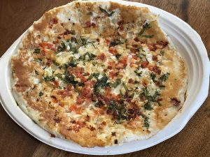 Shreeji's tomato chili onion uttapam looks a lot like a pizza, but it's full of robust Indian flavors built on a thin rice and lentil cake.