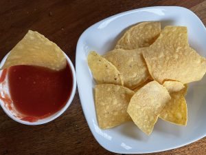 Crackling crisp, freshly fried tortilla chips and mild but tomato-rich salsa at Taco Choza.