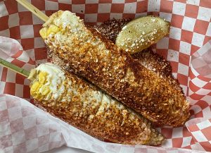Taco Choza's street corn elotes bear a tasty schmear of queso and a generous shake of red chile powder.