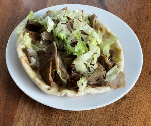 The gyros at Alwatan is loaded with chunks of rough-sliced beef-lamb gyros meat, lettuce, tomato, and tzatziki on a grilled fresh pita.   