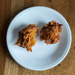 Tikka House's onion pakora appetizers are  golf-ball size balls of onions and spice held together with chickpea-based gram flour batter and fried dark golden-brown.