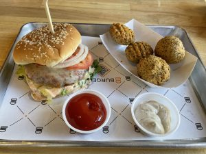 The new aloo tikki burger at BurgerIM puts a meatless Indian patty of potatoes, peas, and carrots into the more familiar setting of lettuce, cheese, onions, and tomatoes on a sesame seed bun.