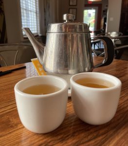 Clear, light jasmine tea with simple, handleless white cups.