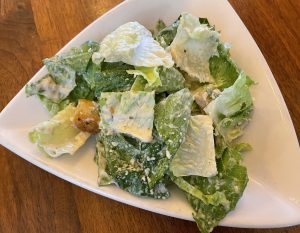 Creamy dressing, crisp iceberg lettuce, and extra-crunchy fresh croutons make Noosh Nosh's Caesar salad a treat.