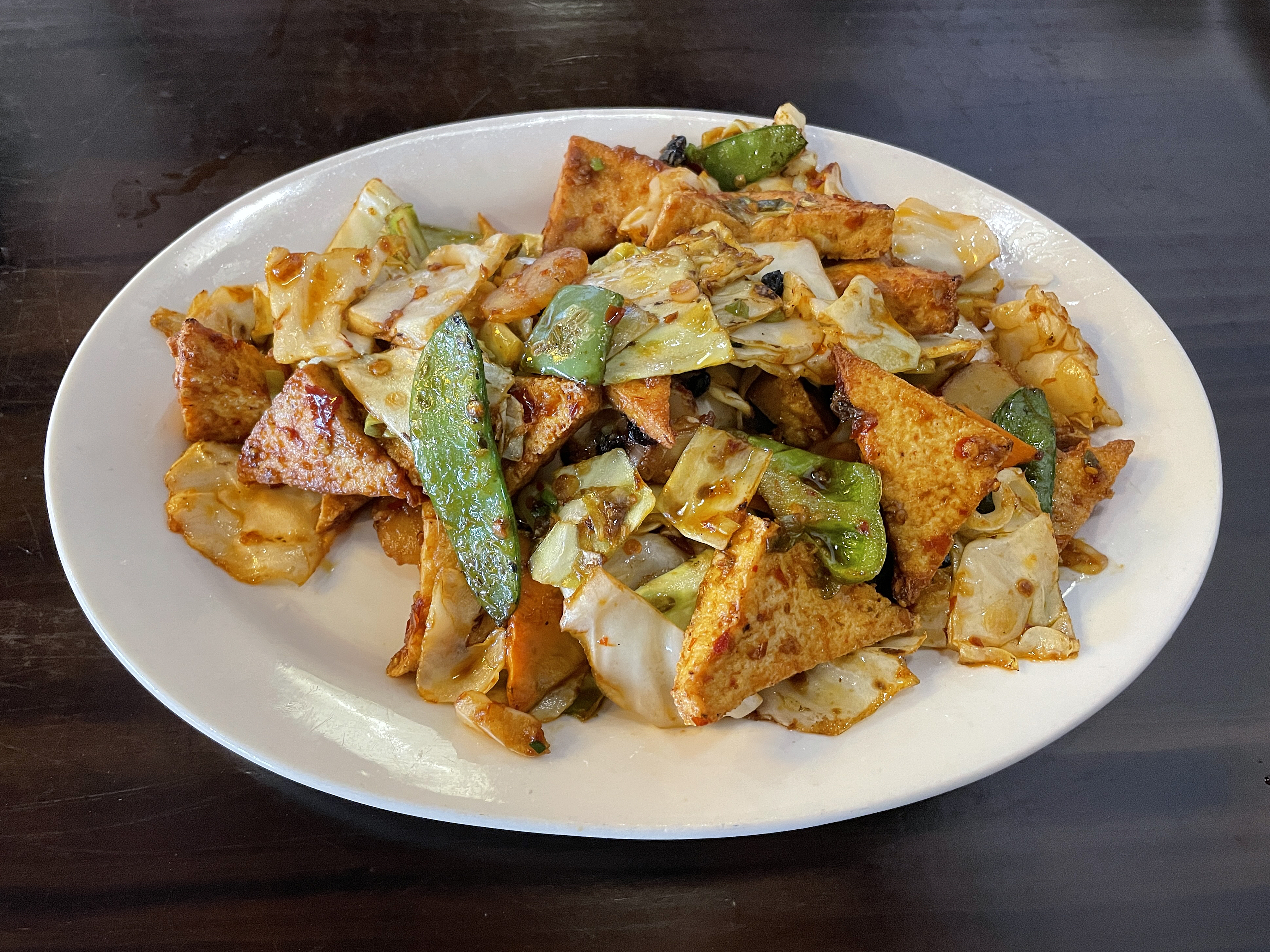 Twice-cooked tofu, a Sichuanese dish at Jasmine Asian Bistro, presents tender tofu crisp-fried and bathed in spice.