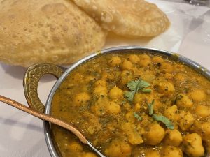 Chana masala, an iconic chickpea curry from Northern India, is fiery and delicious. It's traditionally served with puri, puffy wheat-bread pillows.