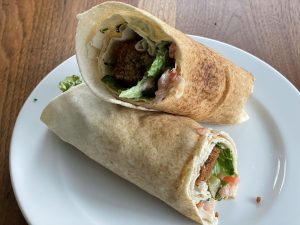 A falafel Saloova wrap, fondly named after the owners' mother, wraps dense falafels, pickles, and lettuce in a thin markouk bread wrap.