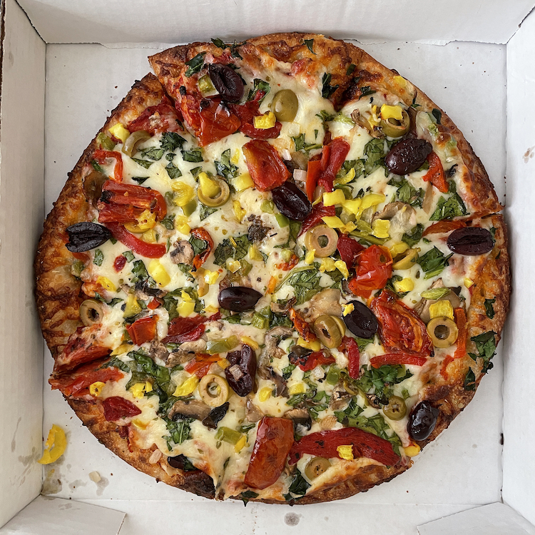 One of the pizzas listed as Bennie's Original Specialties, the veggie pizza piles tangy tomato sauce, melty mozzarella, and crisp, fresh veggies atop a sturdy, bready base.