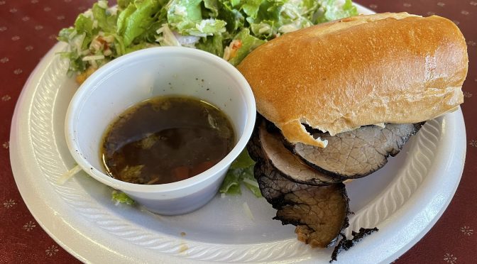 Alley Cat Cafe's version of a classic french dip roast beef sandwich comes sliced on a hoagie roll with a cup of salty bouillon for optional dipping.