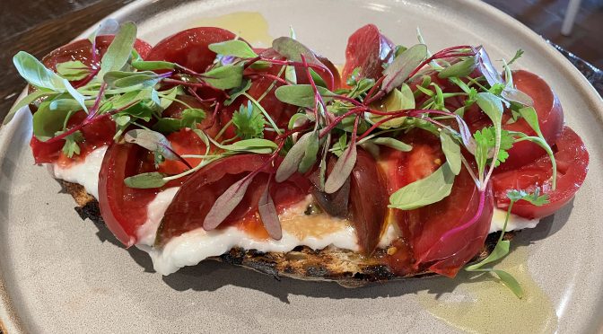 A delicious seasonal heirloom tomato appetizer got a flavor kick from seriously garlicky Lebanese toum sauce and house-made sourdough bread.