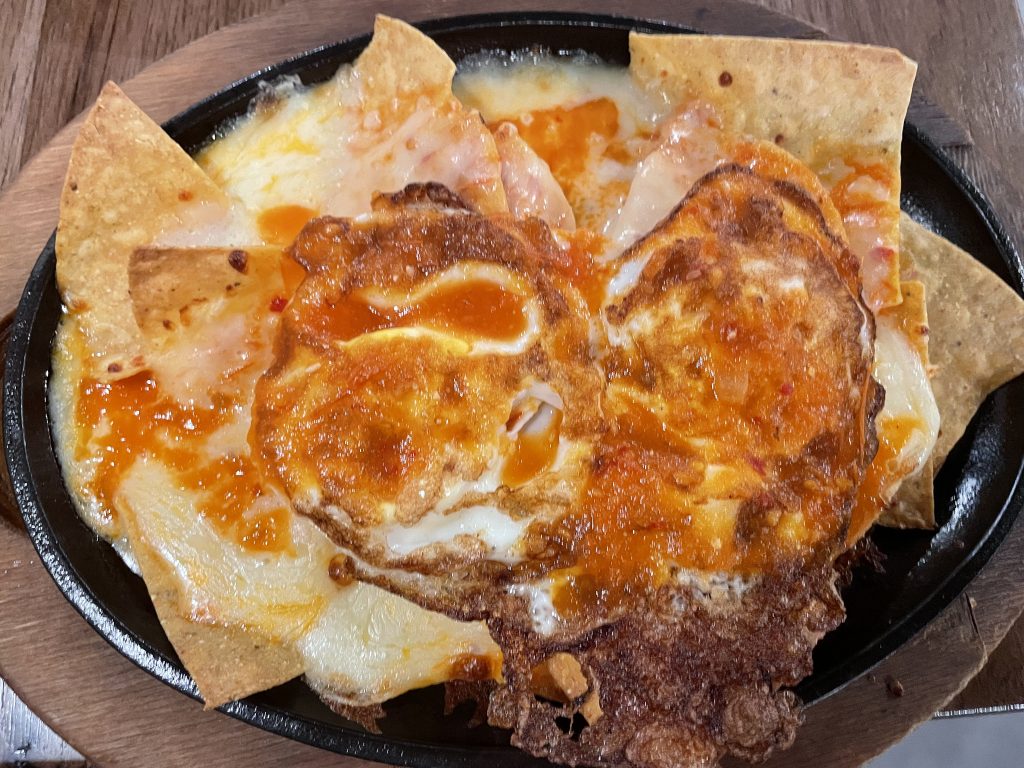 Chilaquiles are Mexico's breakfast of champions, a filling feast of fried tortilla chips slathered with melted cheese, onions, and mild red or green salsa and two eggs fried over hard.