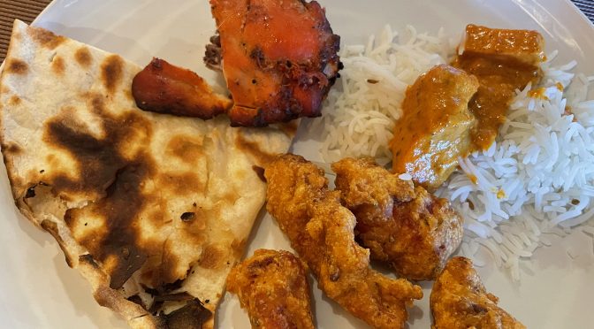 A reddish chunk of tandoori chicken, a couple of bites of chicken tikka masala atop basmati rice, crunchy-fried fish pakora and a quarter of naan bread fill a plate after a buffet run.