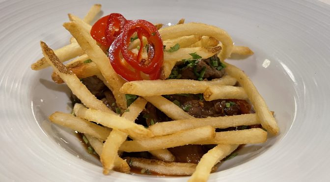 A steak with a Peruvian accent, lomo saltado is a beefy appetizer (topped with crisp fries and zippy red peppers) big enough to serve as a main dish.