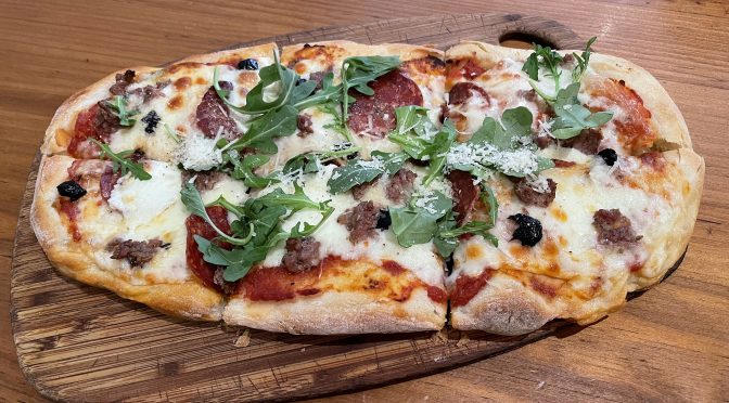 Is it a pizza? Well, not exactly. Nevertheless, a hand-formed flatbread dressed with tomato sauce, cheese, and Red Hog sausage and pepperoni fills a pizza-size space, in a good way.