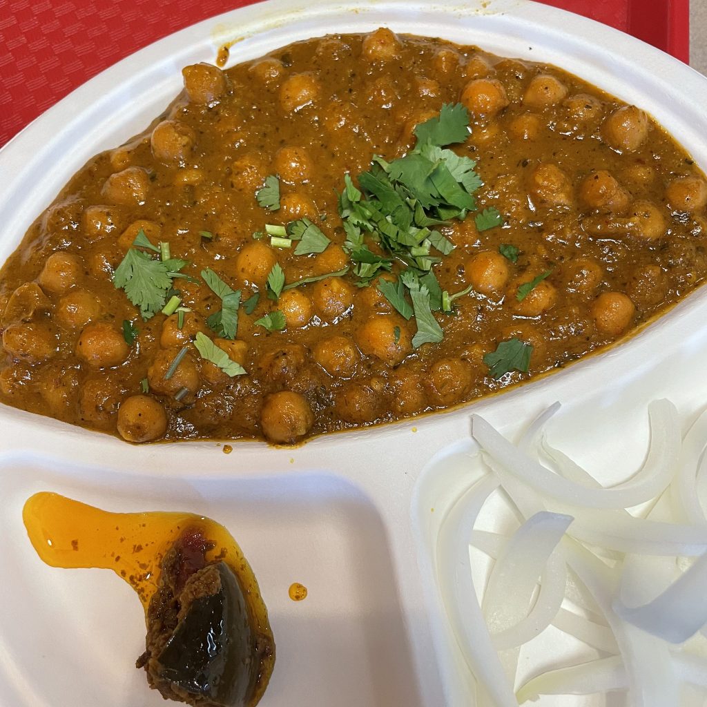 Chole Bhature, a Punjabi dish on Shreeji's chaat menu, brings tender chickpeas in a spicy red-chile sauce, with puffy fried puri bread alongside.